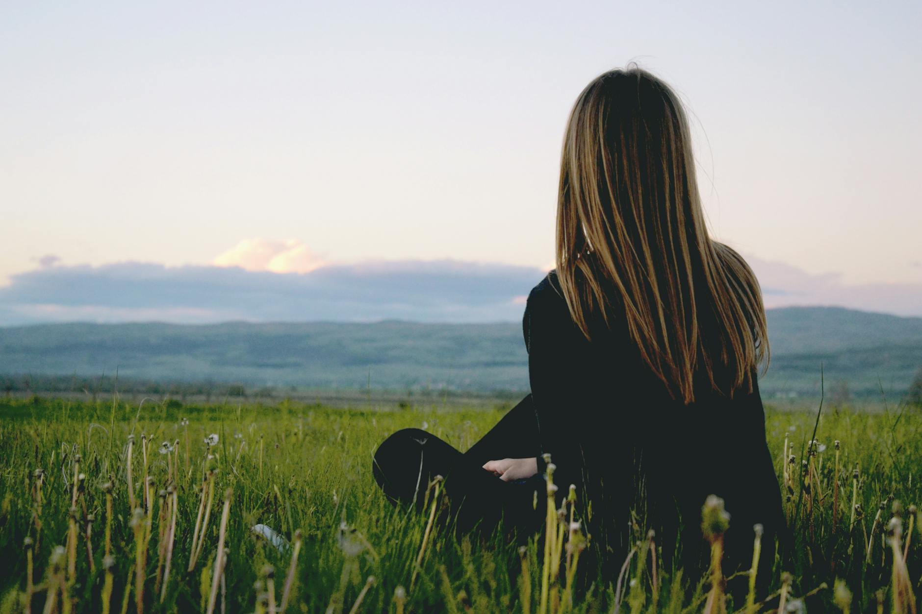 woman wearing black long sleeved shirt sitting on green grass field
Photo by Jure Širić on Pexels.com