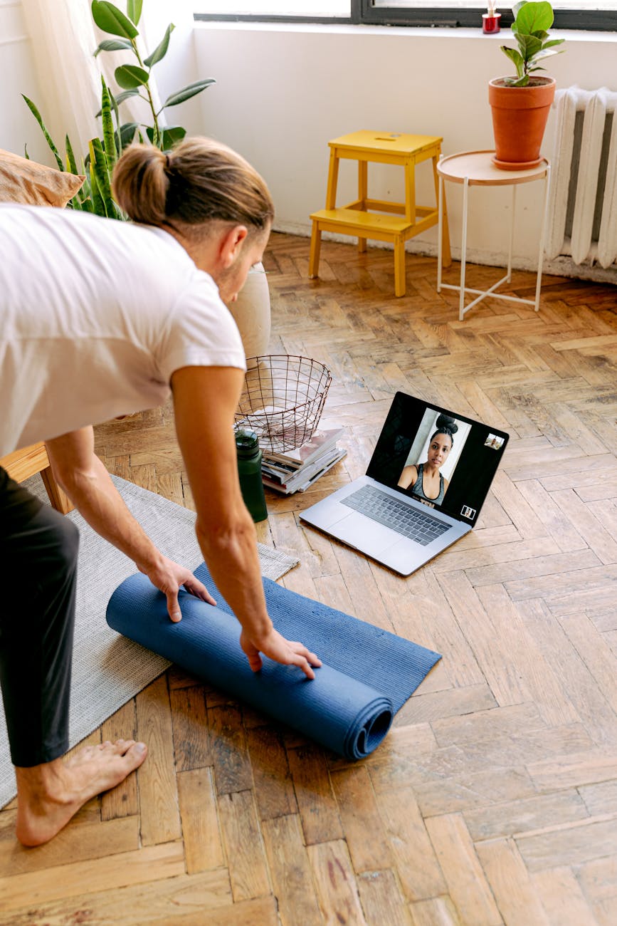 a man in white shirt holding his yoga mat while talking to the woman at the laptop screen
Photo by Antoni Shkraba Studio on Pexels.com